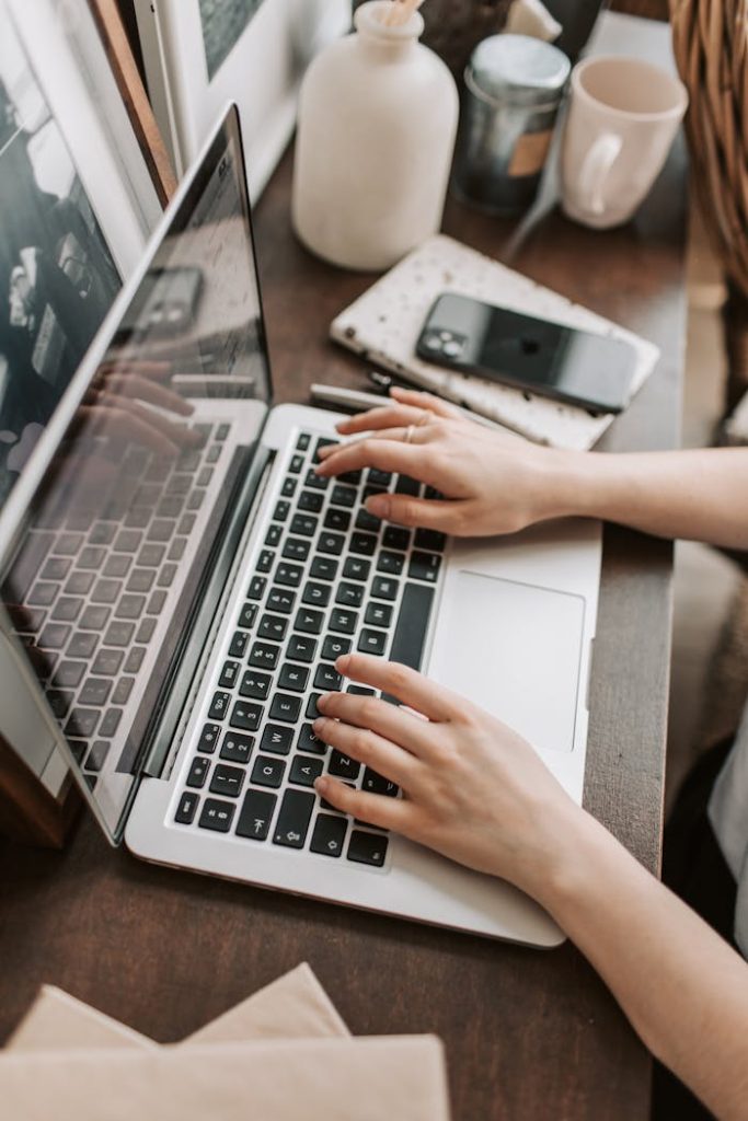 crop-female-freelancer-using-laptop-at-table-at-home-4050312 From above of unrecognizable woman sitting at table and typing on keyboard of computer during remote work in modern workspace