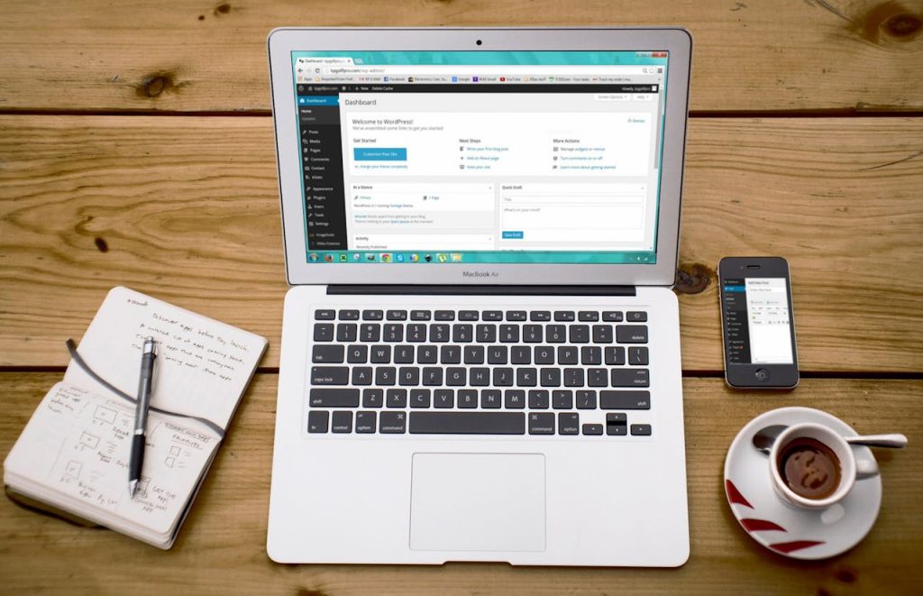 turned-on-macbook-air-beside-black-iphone-4-cup-of-tea-and-notebook-on-brown-wooden-surface-265667 A cozy home office scene with a laptop, notebook, smartphone, and coffee, perfect for productivity.